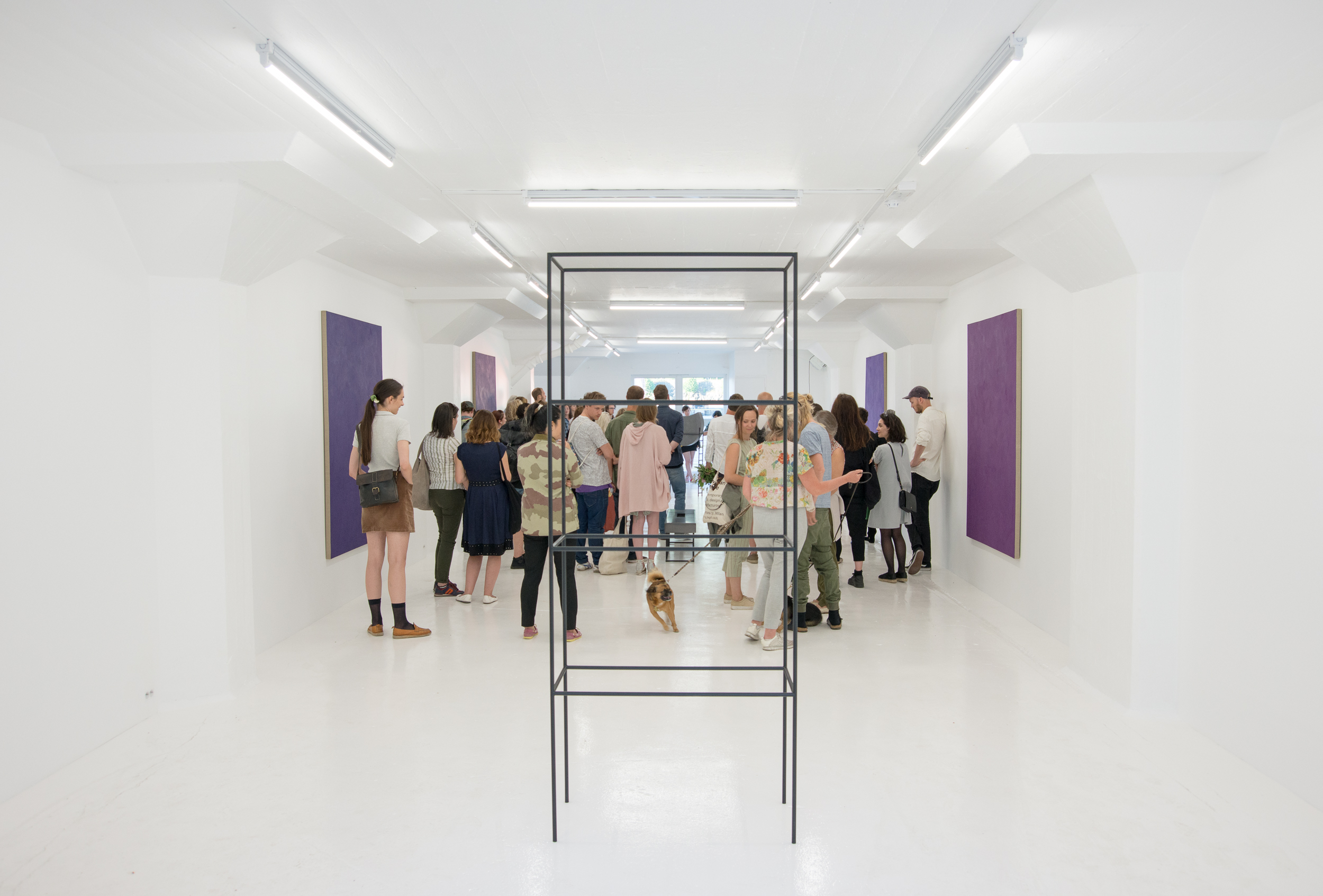 Aldea's 2018 grand-opening night — a crowd gathered in the white gallery among purple paintings and a steel sculpture.